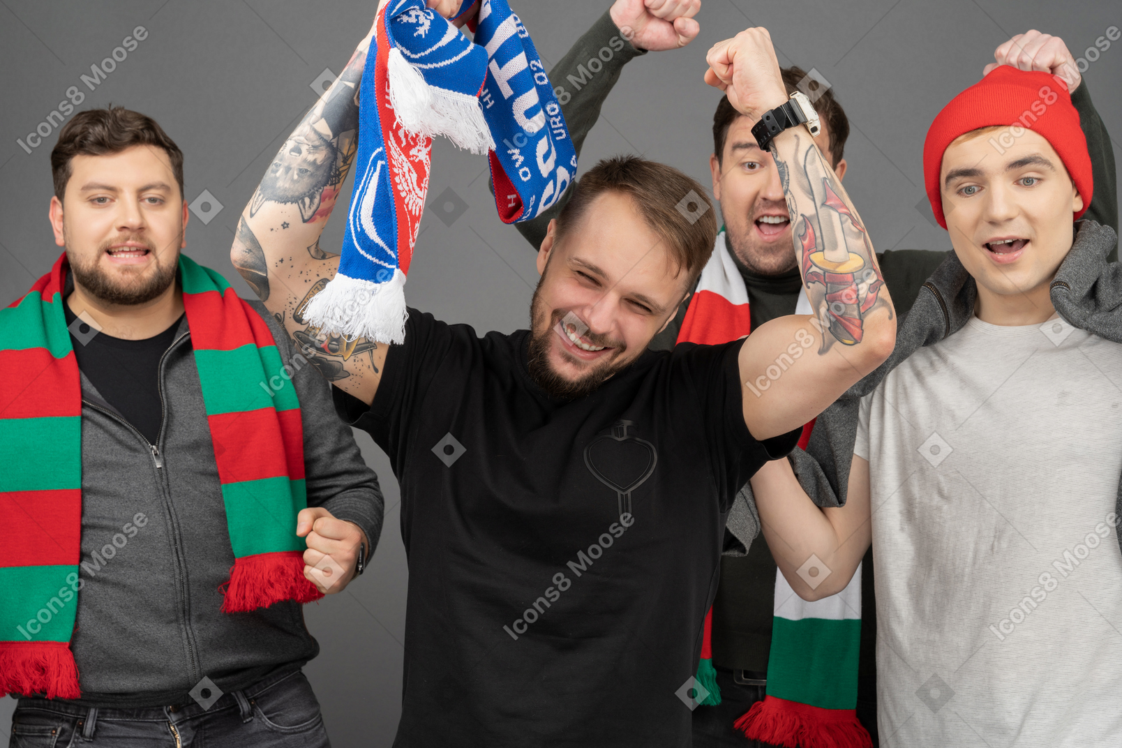 Close-up of four male football fans celebrating the victory & raising hands