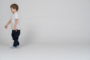 Vista lateral de un niño alegre caminando