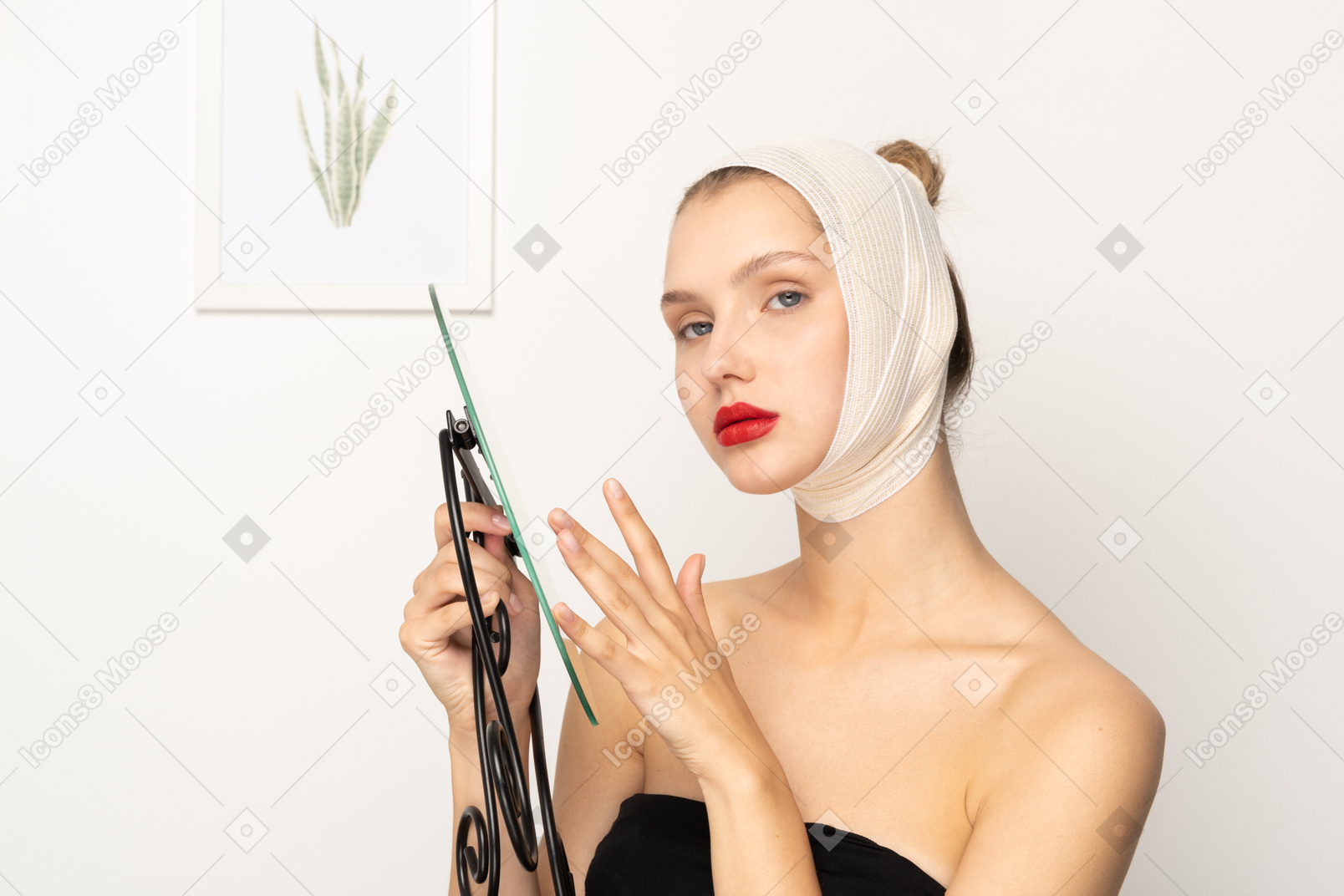 Young woman with bandaged head holding a mirror