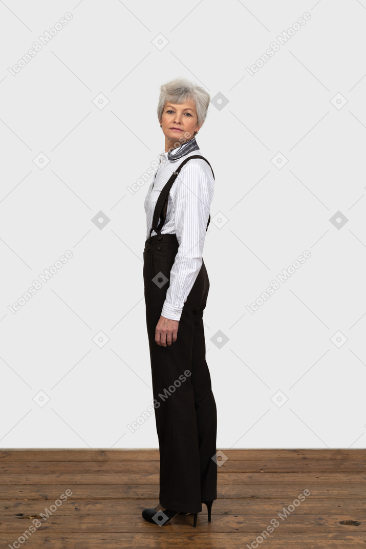 Full-length if an old female in office clothes turning back