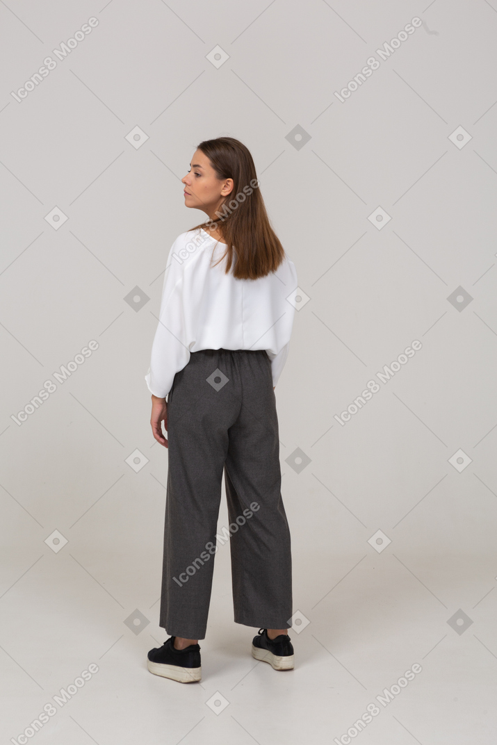 Back view of a young lady in office clothing looking to the left