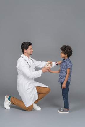 Doctor dando un juguete al niño