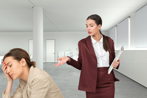 A woman in a business suit standing next to a woman in a suit