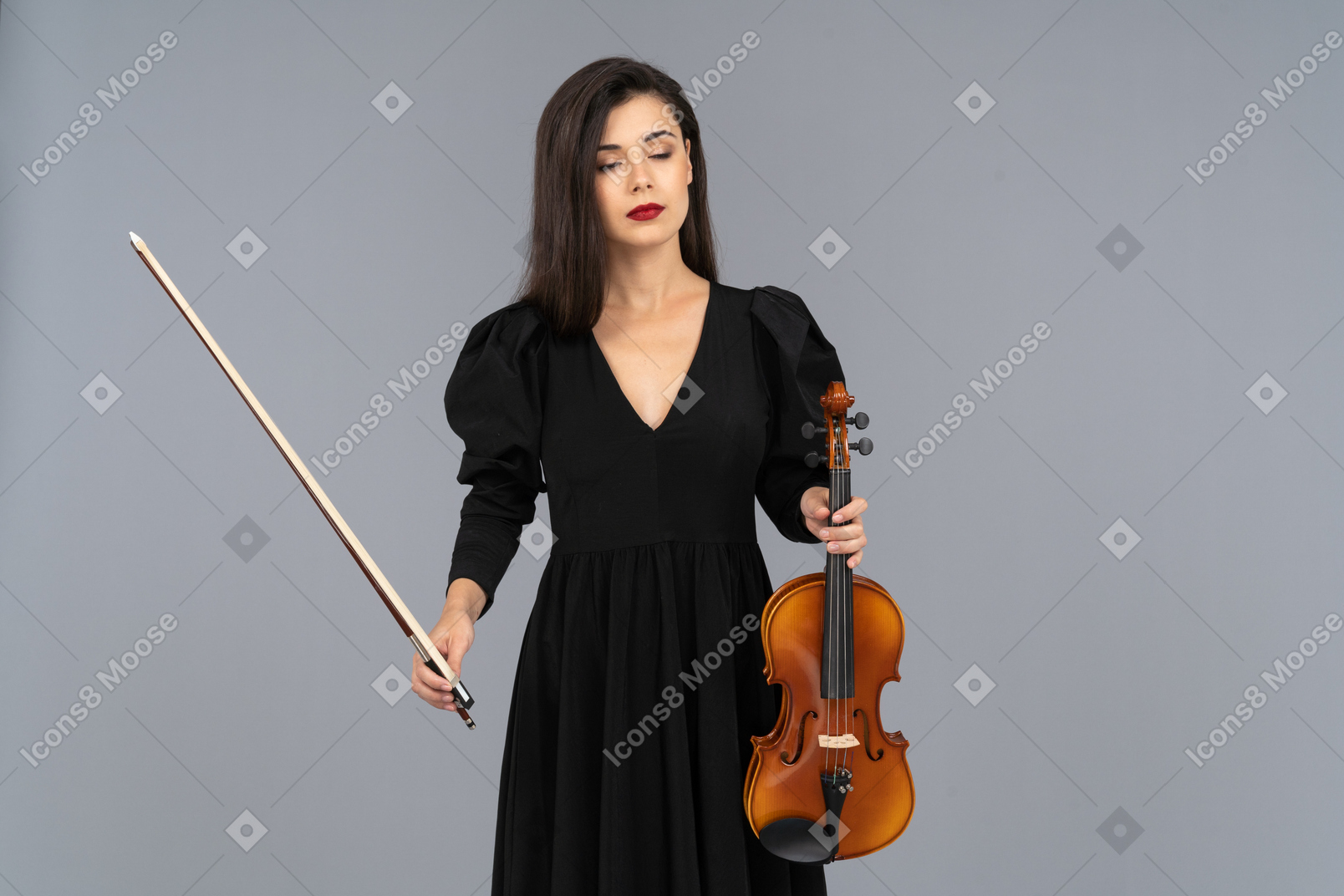 Close-up of a young lady in black dress holding the violin and the bow