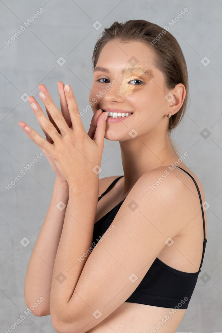 Donna sorridente con diverse sfumature di fondotinta sulla pelle