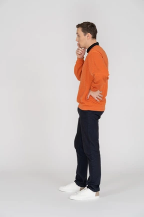 Young man in orange sweatshirt standing
