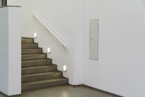 Staircase lighting in a white hallway