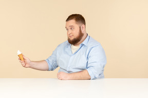 Big man sitting at the table and holding ice cream