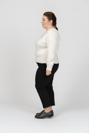 Plump woman in casual clothes standing in profile