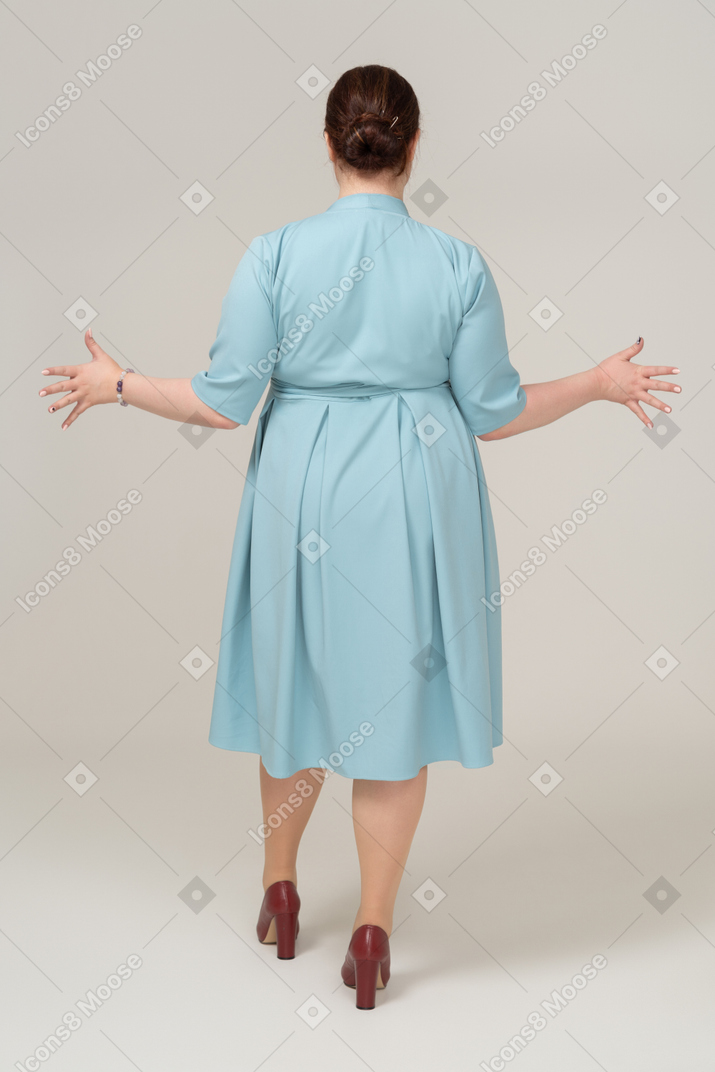 一个穿着蓝色裙子的女人的后视图打手势
