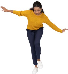 Front view of a girl in casual clothes bending down with outstretched arms