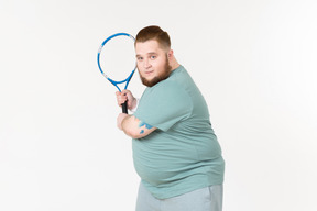 Tipo grande en ropa deportiva con raqueta de tenis