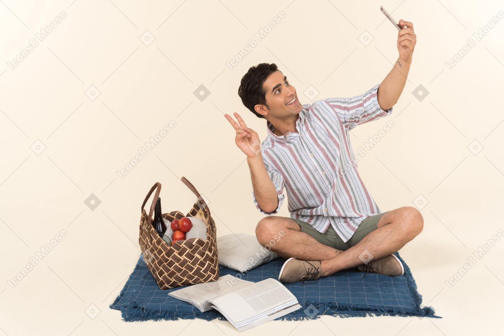 Young caucasian guy sitting on blanket and making a selfie