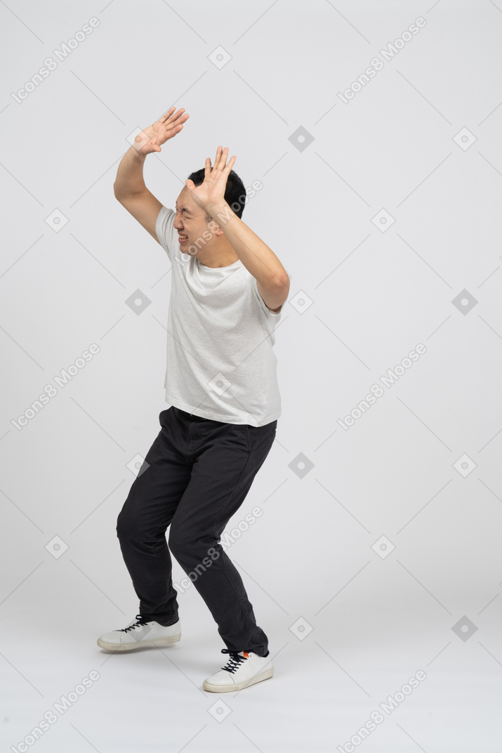 Man standing with raised hands and crying