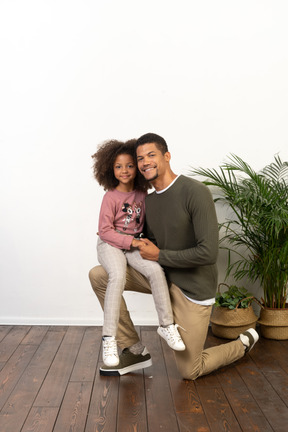 Young man on a knee with his daughter