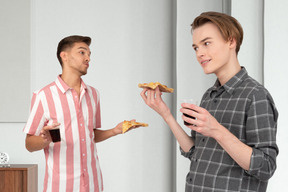 Men eating pizza and talking