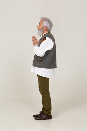 Side view of a man standing with folded hands