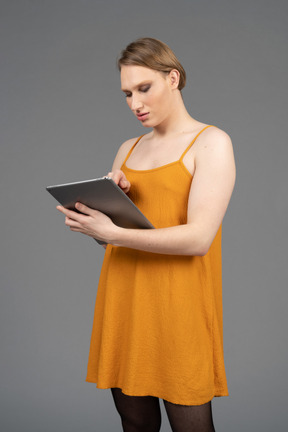 Portrait of a transgender person tapping on tablet screen