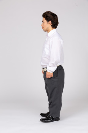 Side view of a young man standing and looking away