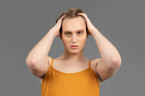 Young non-binary person smoothing down their hair