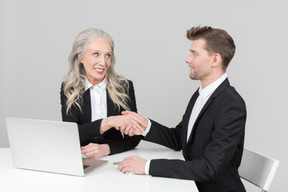 An older woman and a young man working together