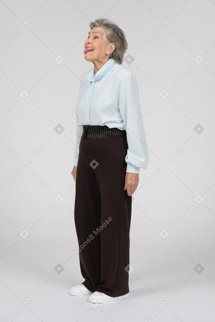 Side view of an old woman sticking tongue out playfully