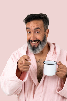 An old man holding a cup and smiling