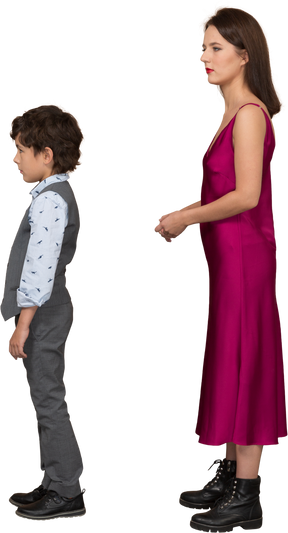 Young woman in dress standing and holding her hand with boy