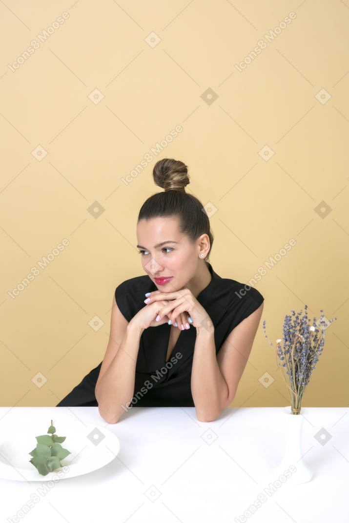 Elegant young woman sitting at the table