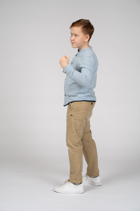 Side view of a boy showing fist