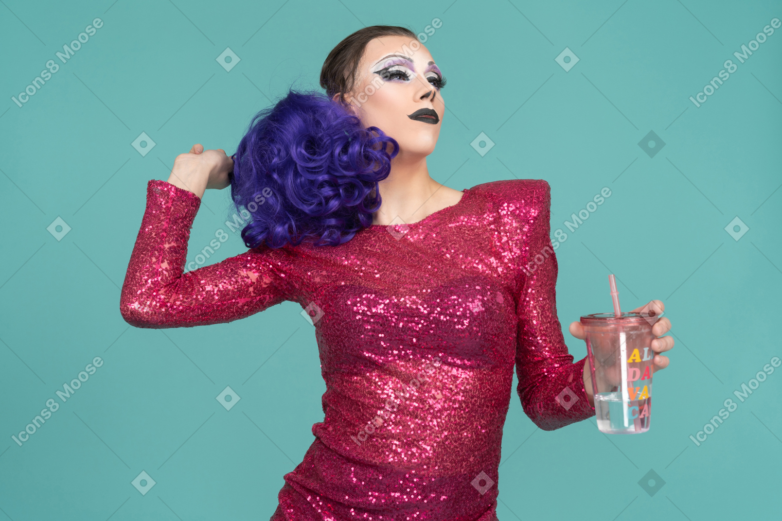 Drag queen en vestido rosa luciendo confiado con bebida en la mano