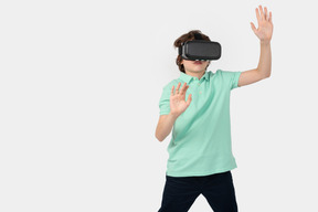 デジタル世界で想像上の壁に触れる vr ヘッドセットの少年