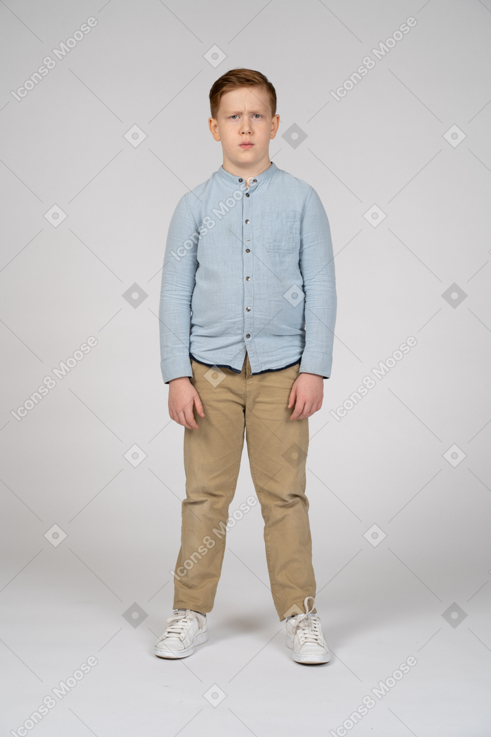 Boy in casual clothes making faces and looking at camera