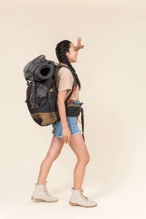 Young asian hiker shielding face from sun