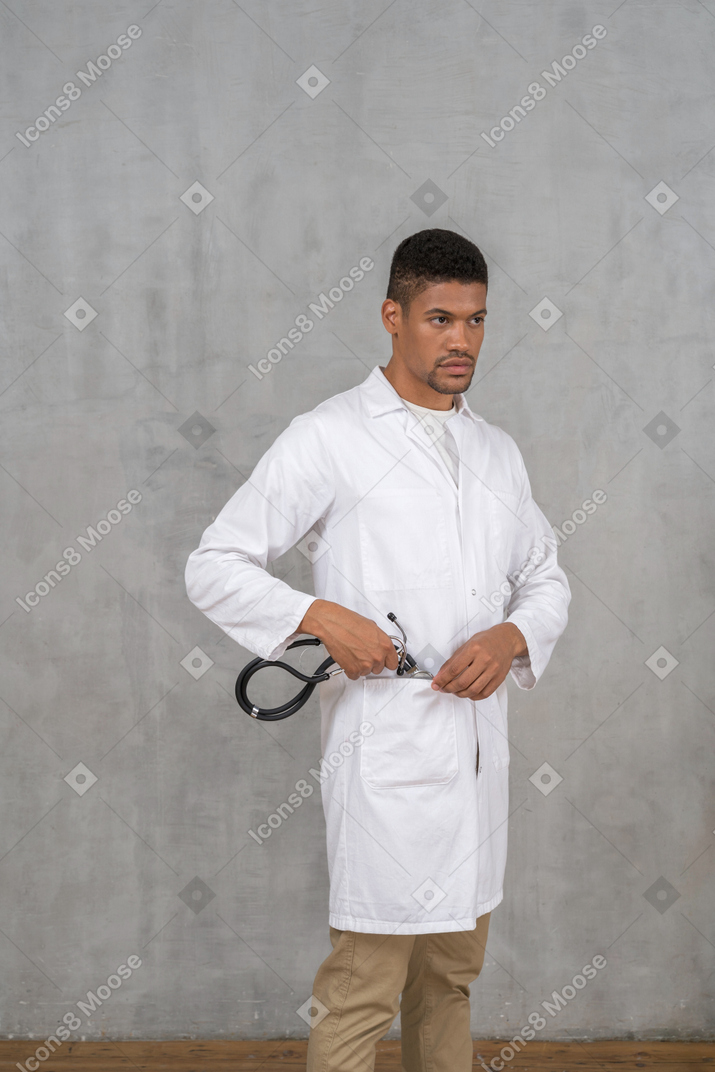 Male doctor putting his stethoscope away