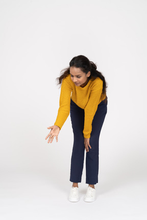 一个穿着休闲服的女孩用伸展的手臂弯下腰的前视图