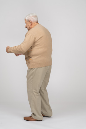 Side view of an old man in casual clothes walking