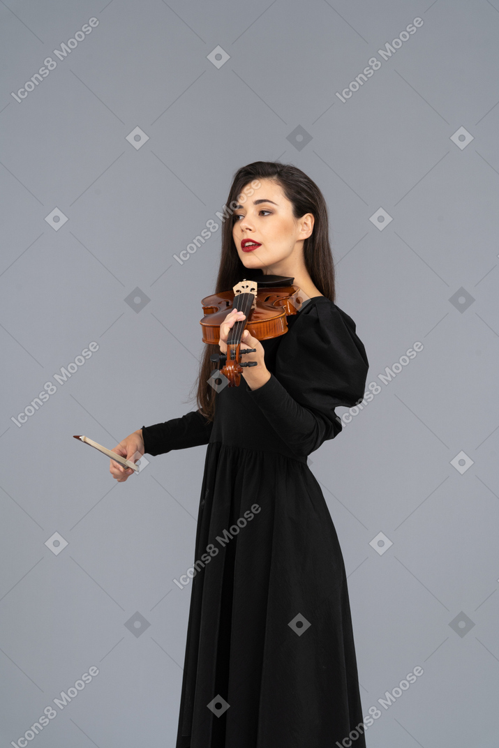 Nahaufnahme einer jungen dame im schwarzen kleid, die geige spielt
