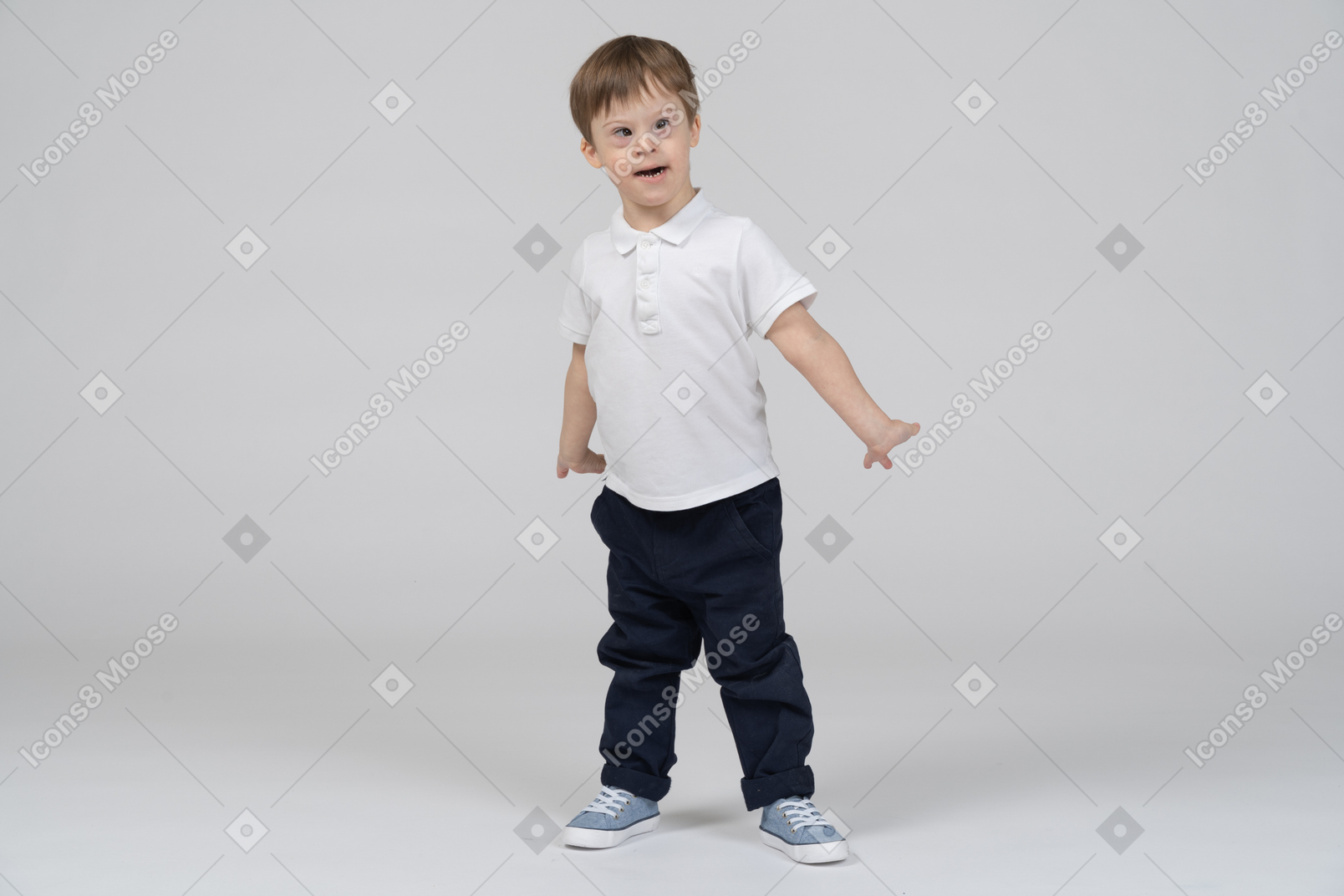Маленький мальчик стоит с руками по бокам