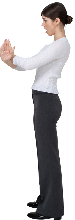 Vista lateral de una mujer joven en ropa de oficina cruzando los brazos