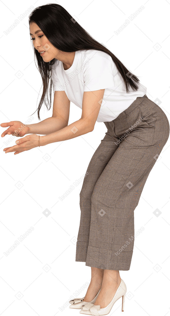 Three-quarter view of a questioning young lady in breeches and t-shirt raising hands and bending down