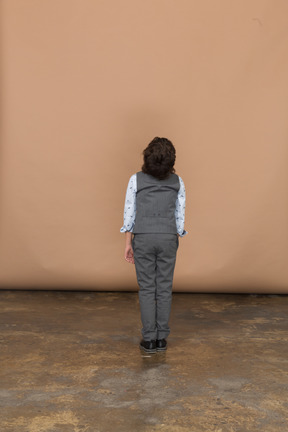 Vista posteriore di un ragazzo vestito che guarda in alto