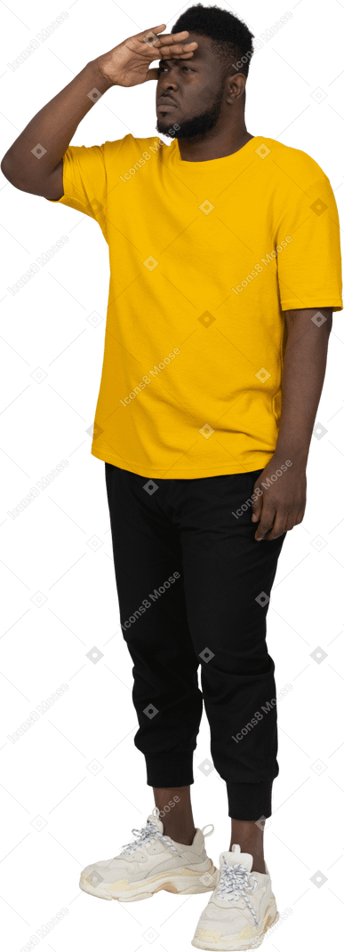 무언가를 찾고 있는 노란색 티셔츠를 입은 검은 피부의 젊은 남자의 4분의 3 보기