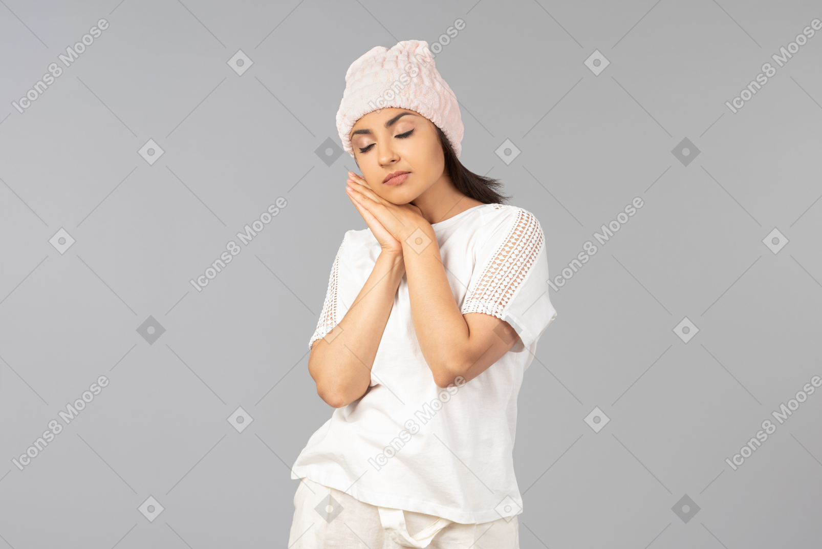 Young indian woman in comfy clothes and pink hat sleeping on hand