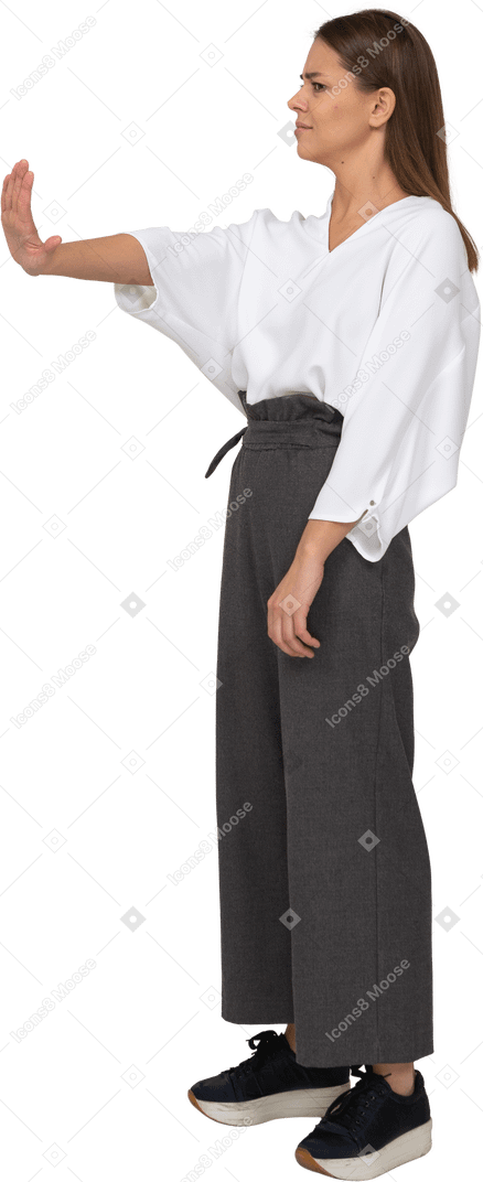 Three-quarter view of a displeased young lady in office clothing outstretching arm