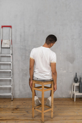 Back view of man sitting and tilting his head