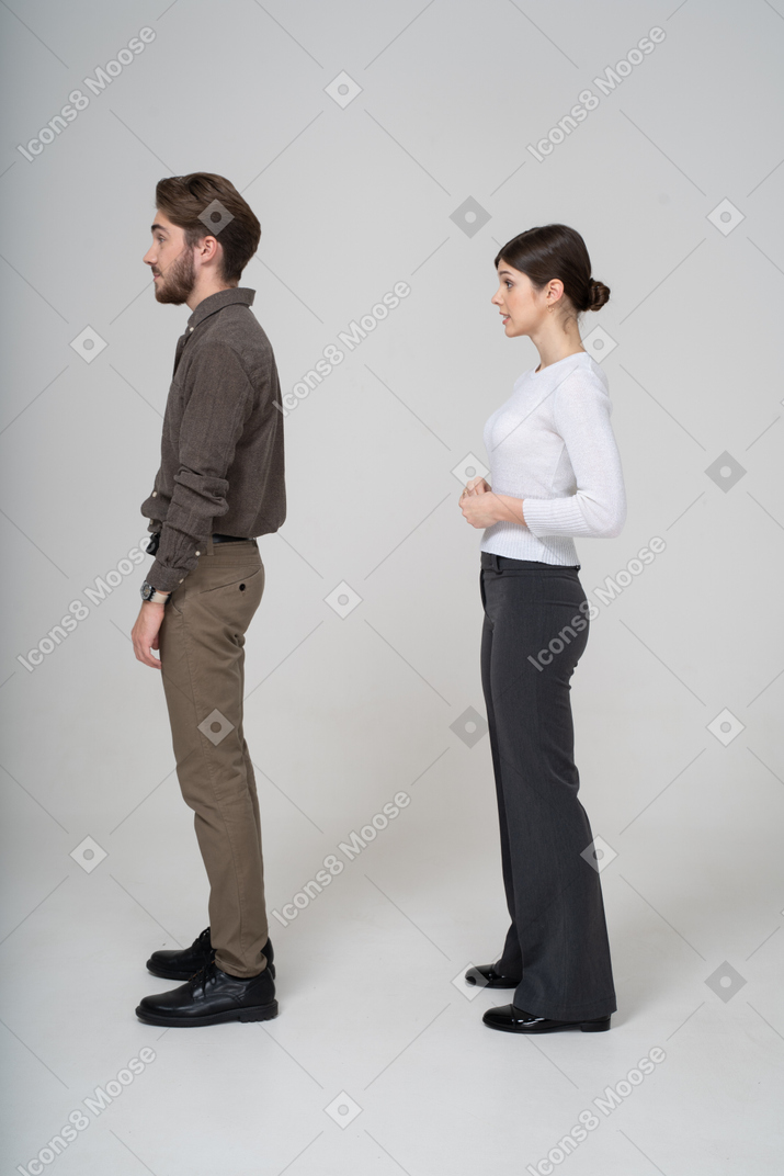 Vista lateral de um jovem casal com roupas de escritório