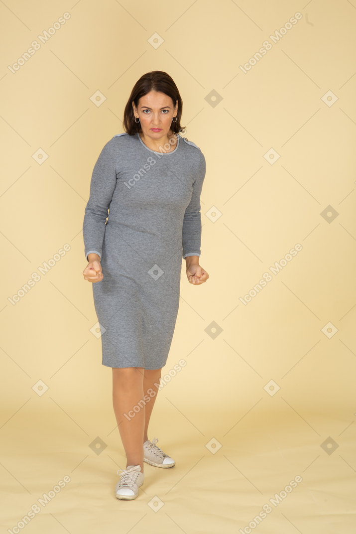 Front view of an angry woman in grey dress