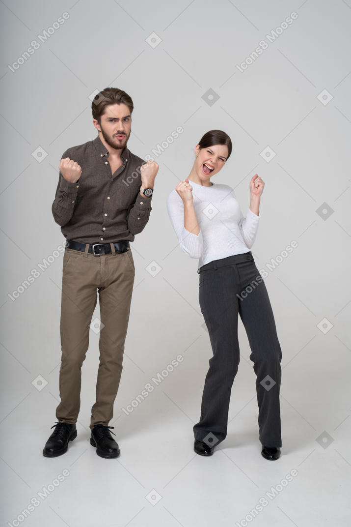 Front view of a delighted young couple in office clothing