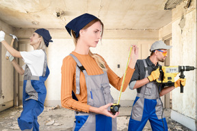 A group of people in overalls holding tools